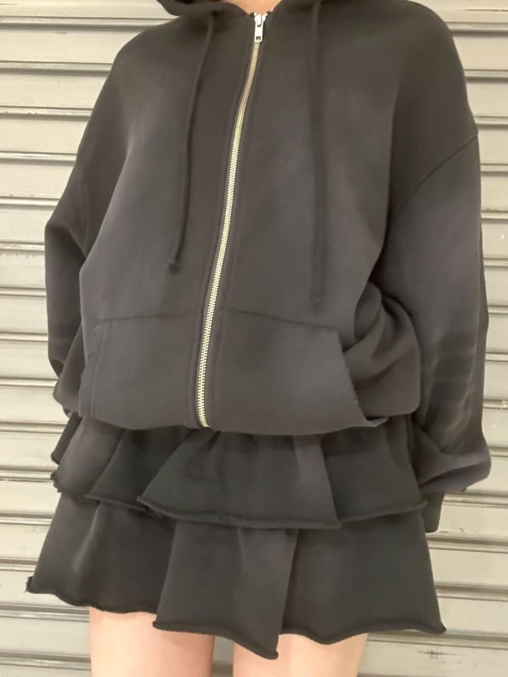 ブラック系のブーツ、グレー系のパーカー、グレー系のスカートを着用したレディースの秋コーディネートの5枚目の写真