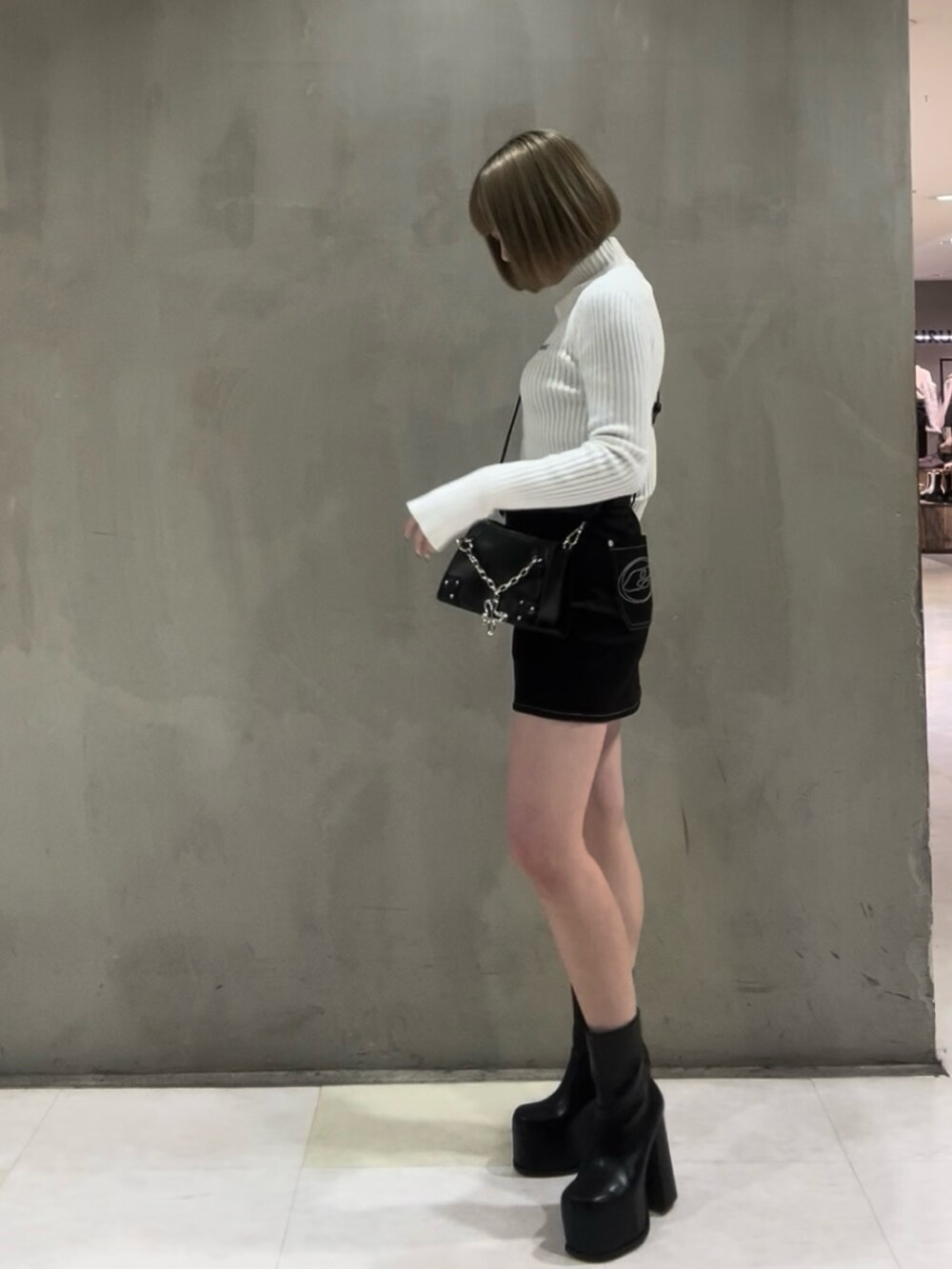 ホワイト系のニット/セーター、ブラウン系のブルゾン、ブラック系のスカートを着用したレディースの冬コーディネートの4枚目の写真