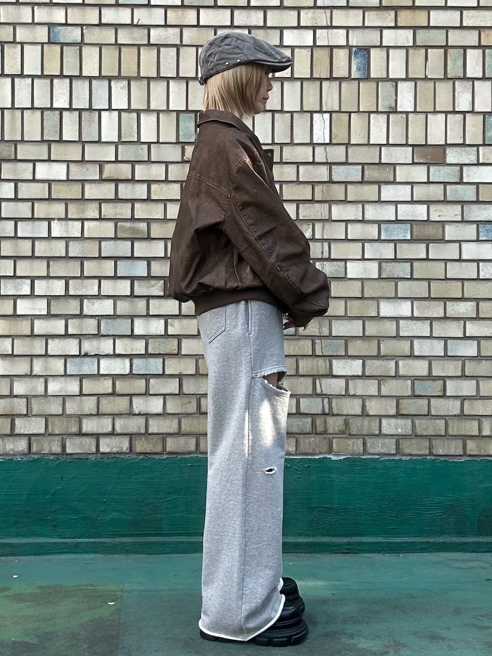 ブラウン系のブルゾン、ホワイト系のTシャツ/カットソー、グレー系のスウェットパンツを着用したレディースの秋コーディネートの3枚目の写真