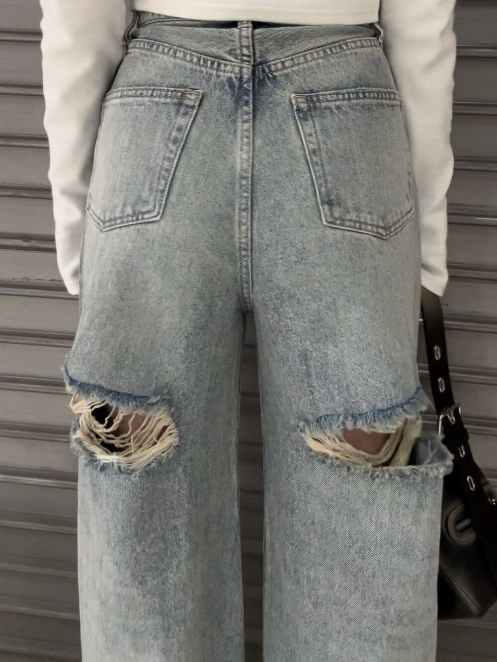 ホワイト系のTシャツ/カットソー、ブルー系のデニムパンツ、ブラック系のハンドバッグを着用したレディースの夏コーディネートの5枚目の写真