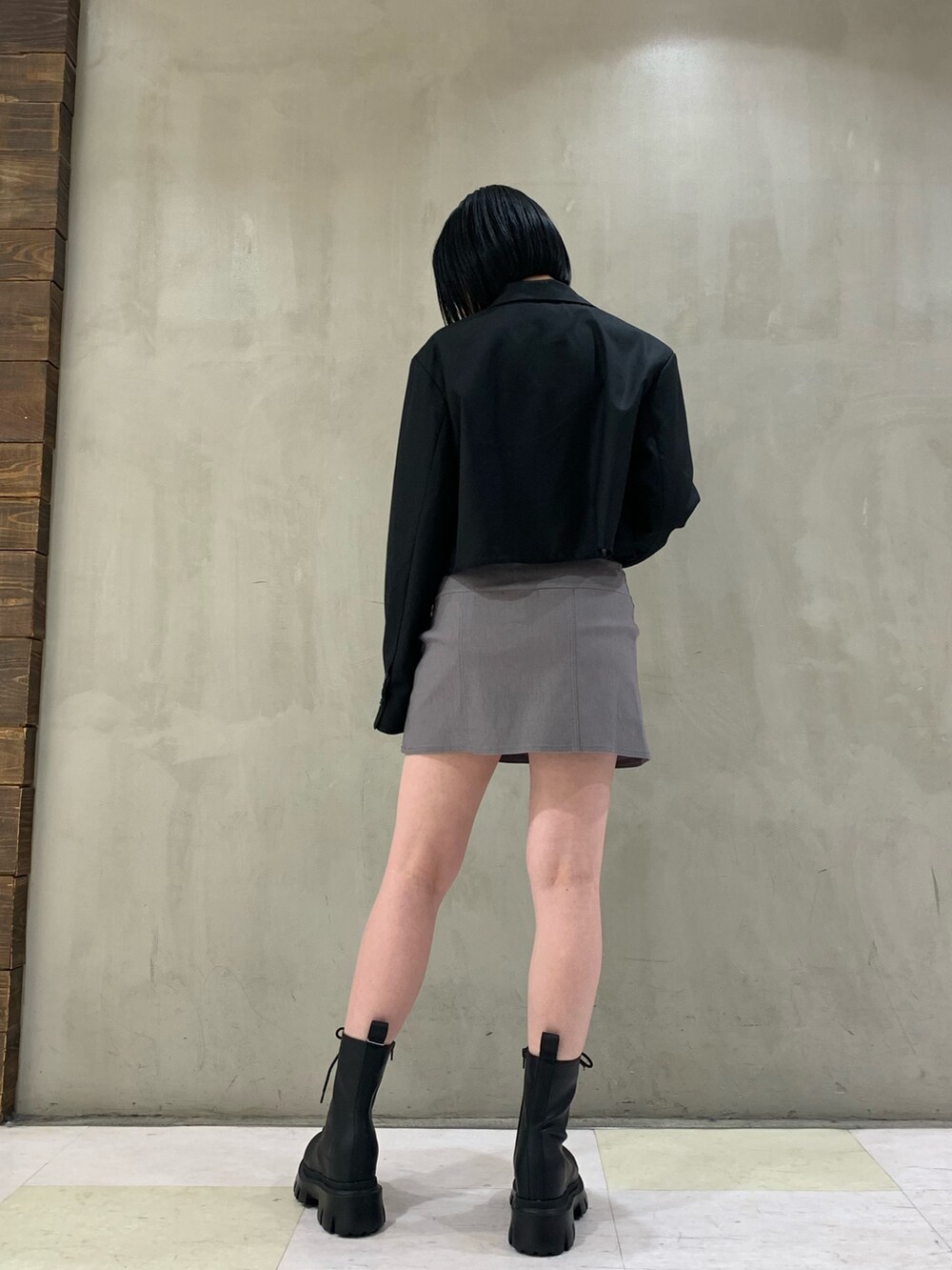 ホワイト系のキャミソール、ブラック系のブーツ、ブラック系のテーラードジャケットを着用したレディースの冬コーディネートの2枚目の写真