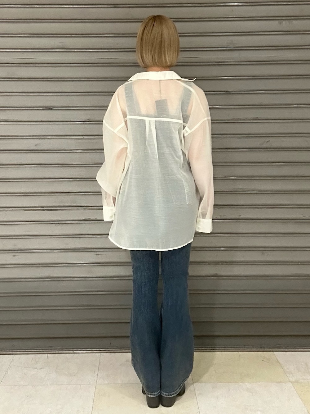 ブルー系のサロペット/オーバーオール、ホワイト系のシャツ/ブラウス、ブラック系のサンダルを着用したレディースの春コーディネートの3枚目の写真