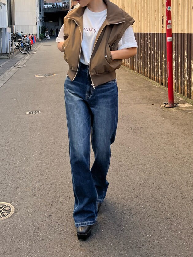 ブラック系のブーツ、ホワイト系のTシャツ/カットソー、ベージュ系のMA-1を着用したレディースの秋コーディネートの2枚目の写真