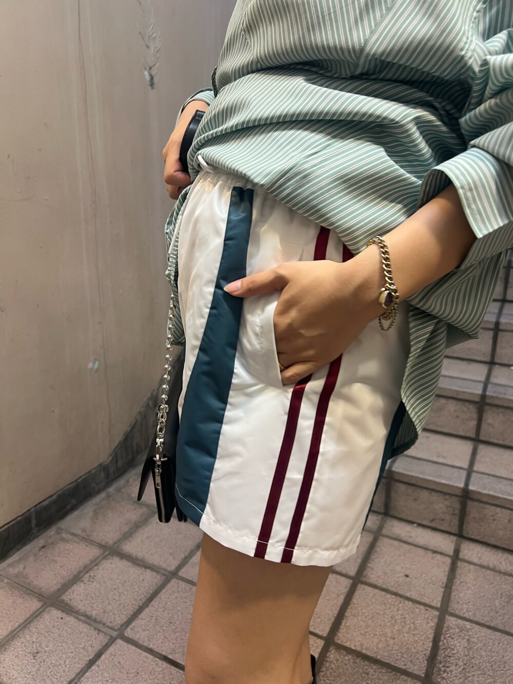 グリーン系のシャツ/ブラウス、ブラック系のブーツ、ホワイト系のその他パンツを着用したレディースの夏コーディネートの7枚目の写真