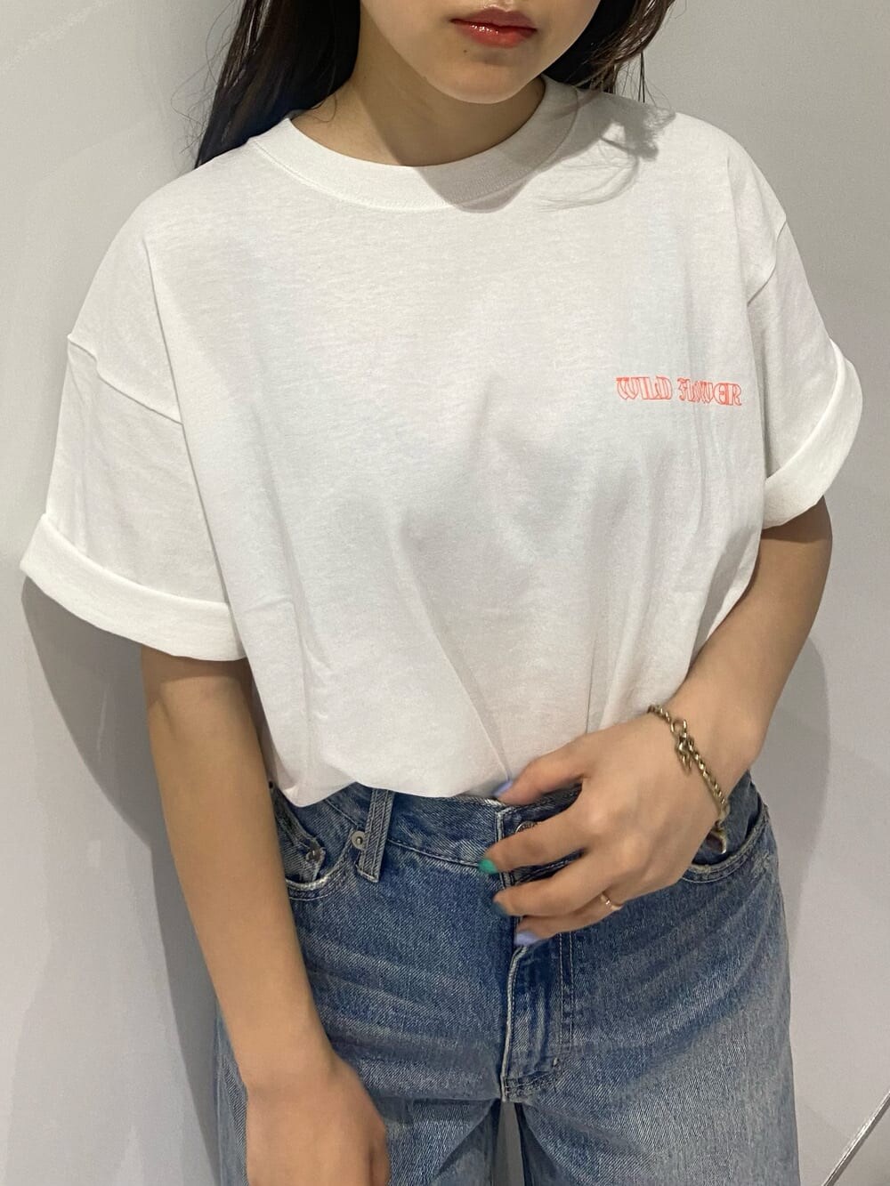 ブラック系のショルダーバッグ、ブラック系のサンダル、ブルー系のデニムパンツを着用したレディースの夏コーディネートの4枚目の写真