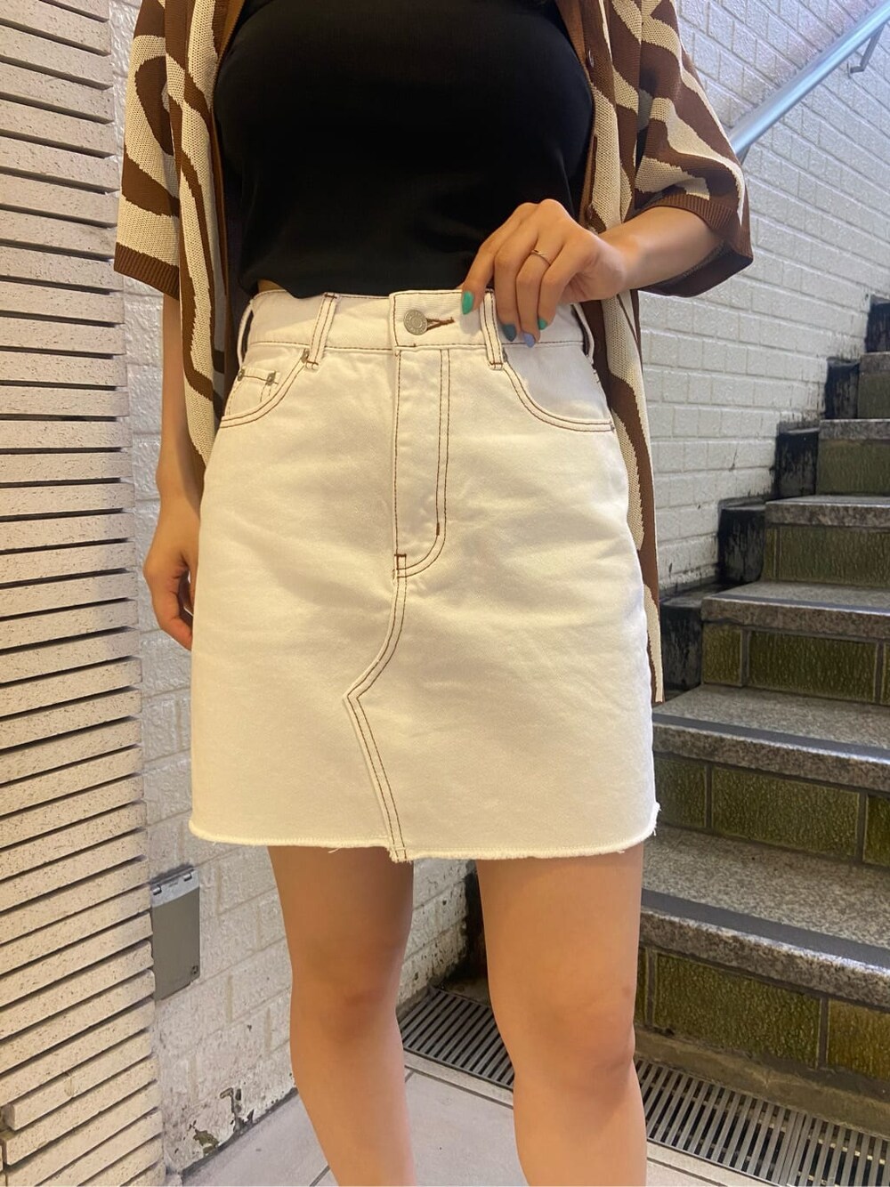 ホワイト系のスニーカー、ブラック系のキャミソール、ブラウン系のニット/セーターを着用したレディースの春コーディネートの6枚目の写真