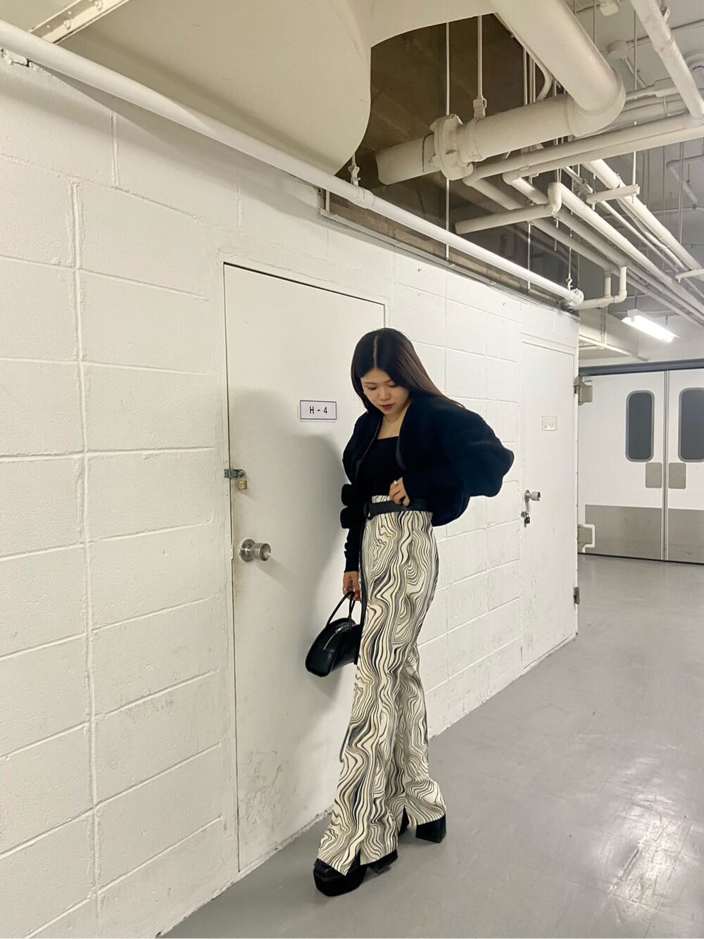 ブラック系のローファー、ブラック系のカーディガン/ボレロ、ブラック系のハンドバッグを着用したレディースの秋コーディネートの6枚目の写真