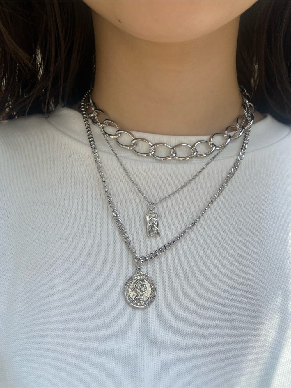 ブラック系のサンダル、ホワイト系のTシャツ/カットソー、ブルー系のデニムパンツを着用したレディースの夏コーディネートの7枚目の写真