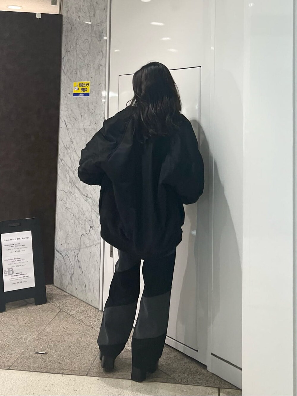 ブラック系のMA-1、ホワイト系のTシャツ/カットソー、ブラック系のデニムパンツを着用したレディースの秋コーディネートの8枚目の写真