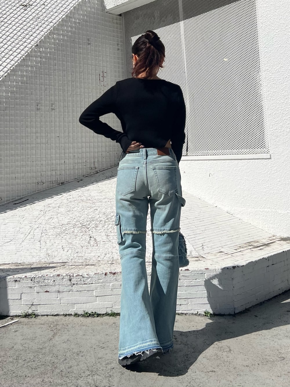 ブルー系のデニムパンツ、ブルー系のショルダーバッグ、ブラック系のTシャツ/カットソーを着用したレディースの冬コーディネートの4枚目の写真