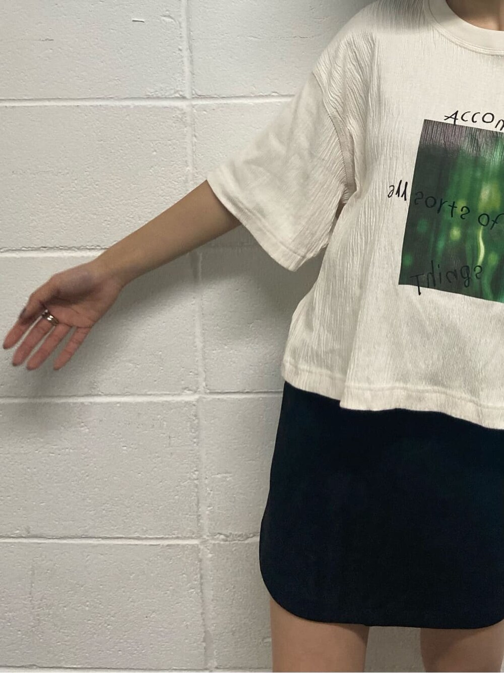 ブラック系のスカート、ブラック系のサンダル、ホワイト系のTシャツ/カットソーを着用したレディースの夏コーディネートの6枚目の写真