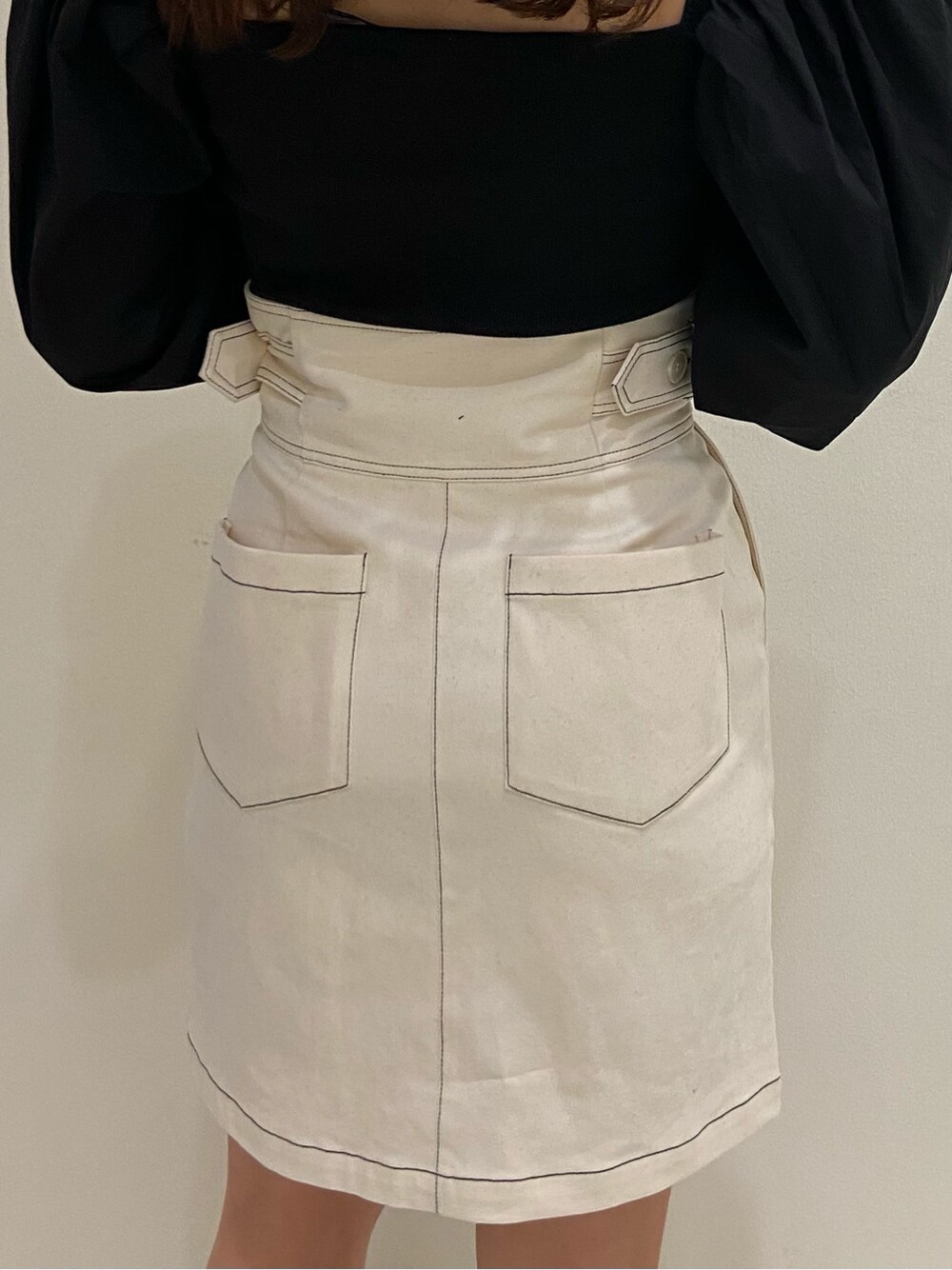 ホワイト系のスカート、ブラック系のサンダル、ブラック系のシャツ/ブラウスを着用したレディースの春コーディネートの3枚目の写真