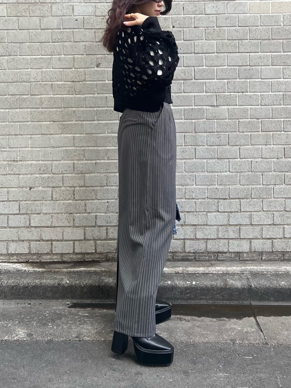 グレー系のスカート、ブラック系のニット/セーター、ブルー系のショルダーバッグを着用したレディースの冬コーディネートの3枚目の写真