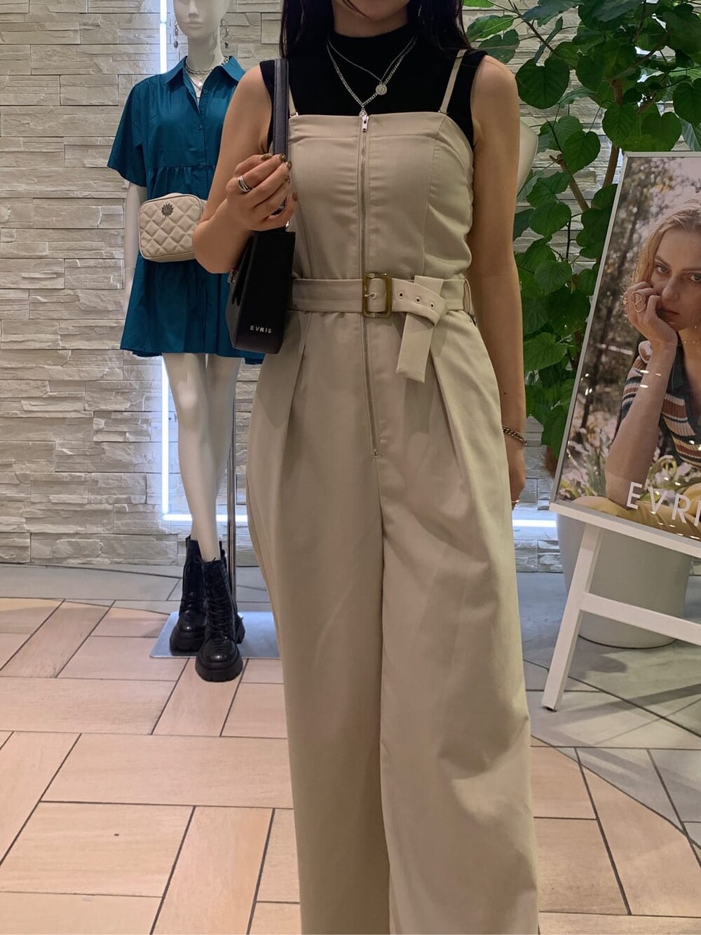 ブラック系のタンクトップ、ホワイト系のサロペット/オーバーオール、ブラック系のショルダーバッグを着用したレディースの夏コーディネートの4枚目の写真