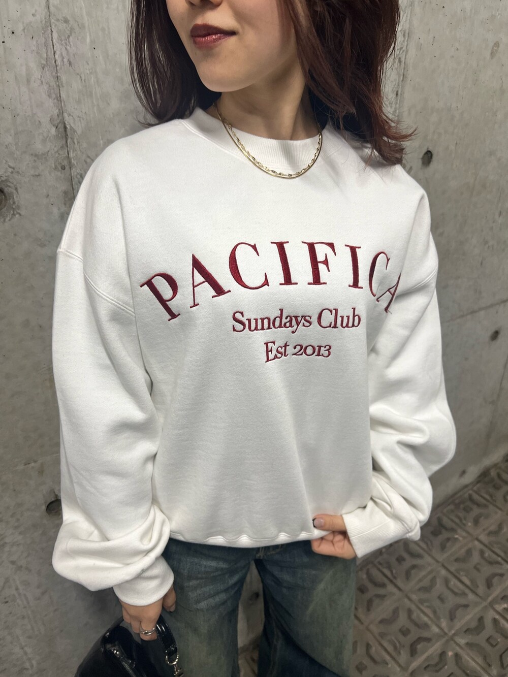 ブルー系のデニムパンツ、ブラック系のブーツ、ブラック系のハンドバッグを着用したレディースの冬コーディネートの6枚目の写真