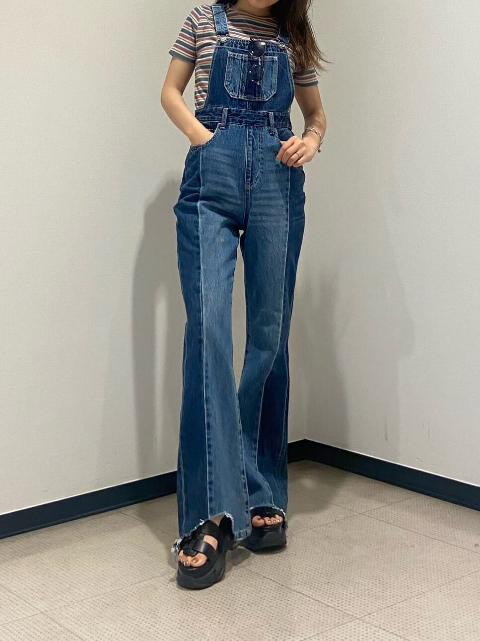 ブルー系のサロペット/オーバーオール、ブラック系のサンダル、グリーン系のTシャツ/カットソーを着用したレディースの夏コーディネートの2枚目の写真