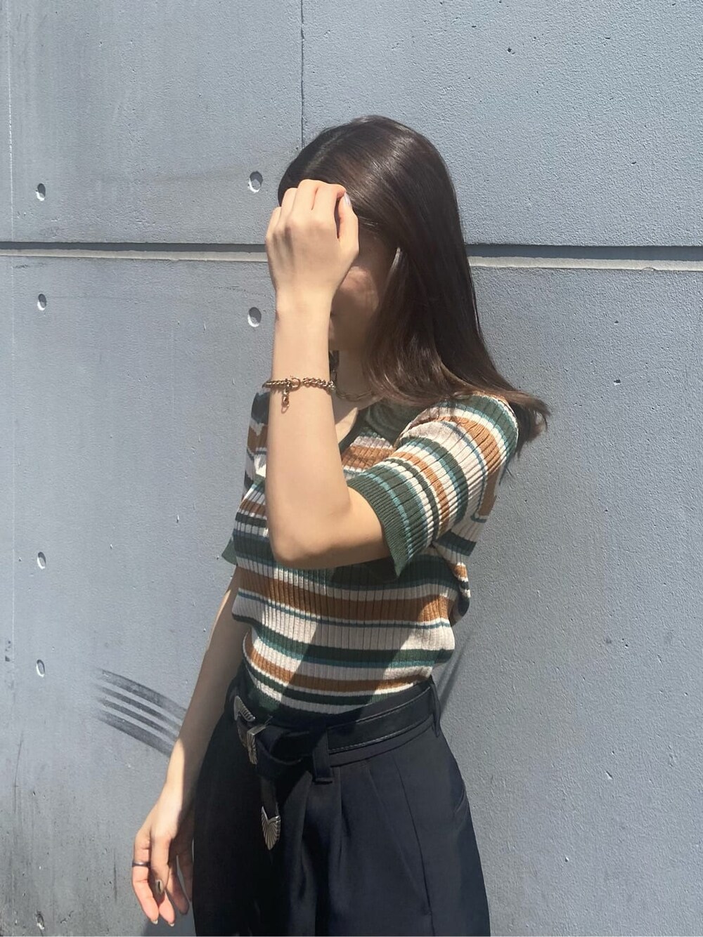 ブラック系のブーツ、グリーン系のニット/セーター、ブラック系のその他パンツを着用したレディースの春コーディネートの5枚目の写真