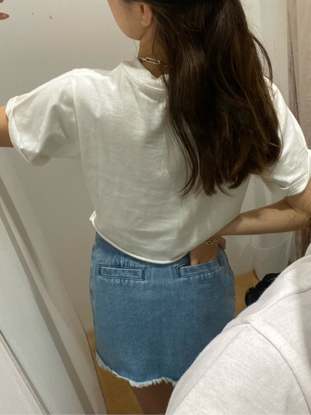 ブルー系のデニムスカート、ホワイト系のTシャツ/カットソー、ホワイト系のサンダルを着用したレディースの夏コーディネートの7枚目の写真