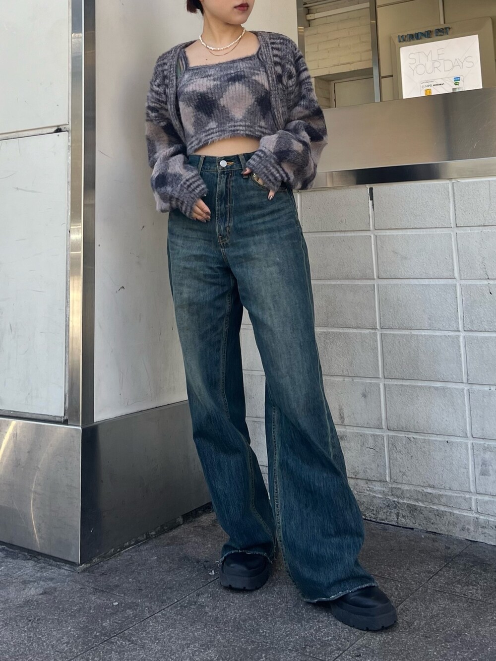 ブルー系のデニムパンツ、ホワイト系のハンドバッグ、ブラック系のブーツを着用したレディースの冬コーディネートの6枚目の写真