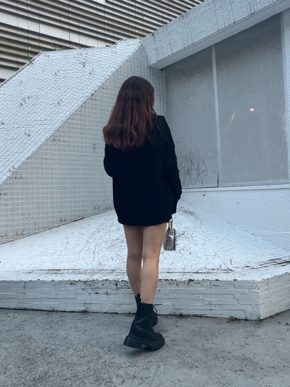 シルバー系のショルダーバッグ、ブラック系のブーツ、ブラック系のその他パンツを着用したレディースの秋コーディネートの3枚目の写真