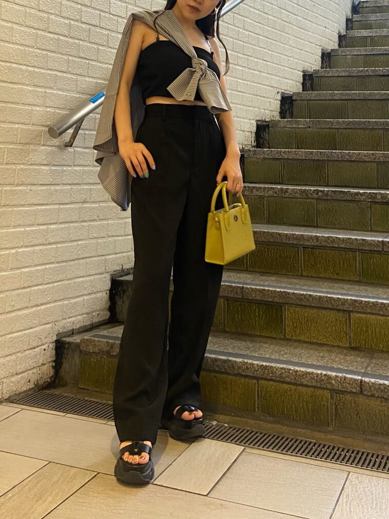 ブラック系のスラックス、ブラック系のサンダル、ブラック系のワンピースを着用したレディースの春コーディネートの2枚目の写真