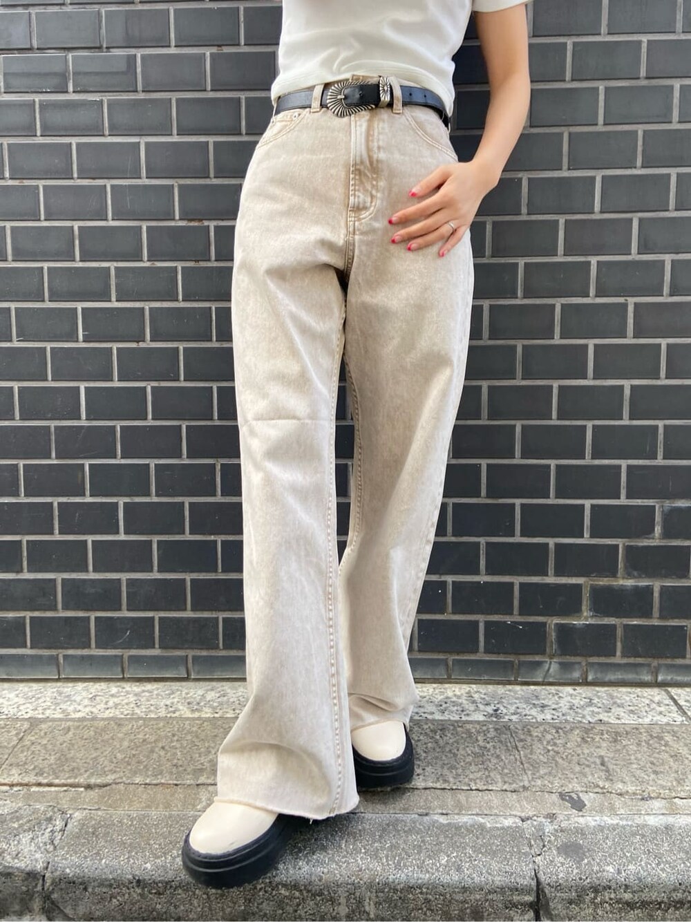 ブラック系のボストンバッグ、ベージュ系のTシャツ/カットソー、ベージュ系のデニムパンツを着用したレディースの春コーディネートの8枚目の写真