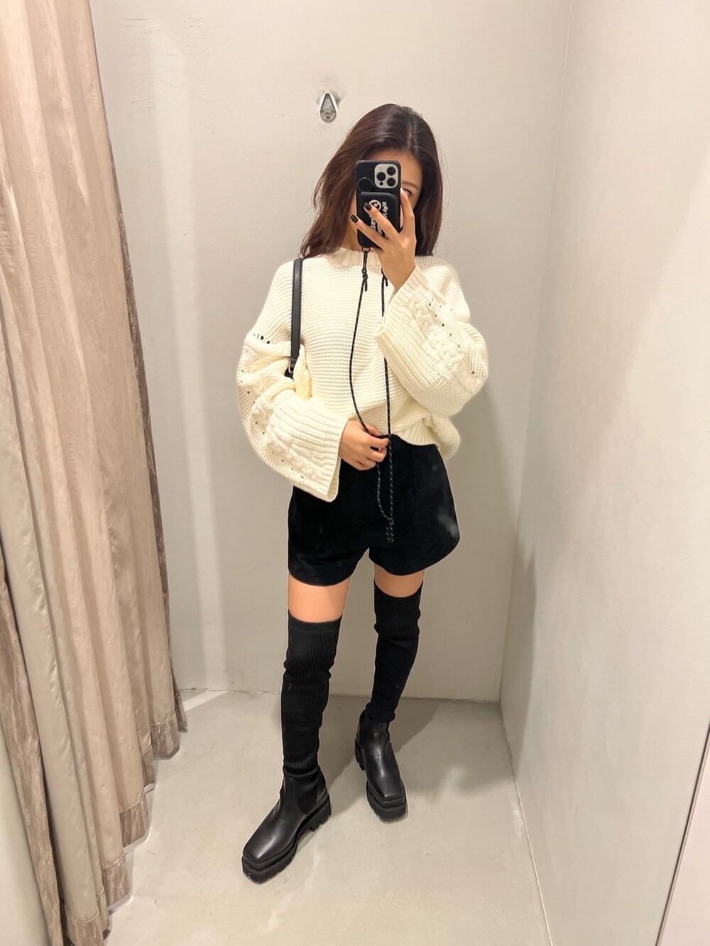 ホワイト系のニット/セーター、ブラック系のその他パンツ、ブラック系のブーツを着用したレディースの秋コーディネートの3枚目の写真