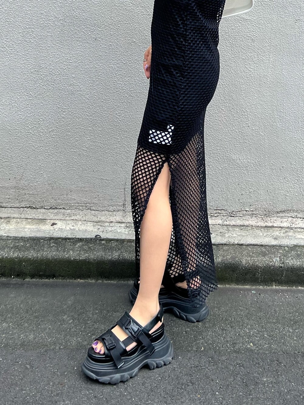 ブラック系のワンピース、ブラック系のサンダル、ホワイト系のハンドバッグを着用したレディースの夏コーディネートの7枚目の写真