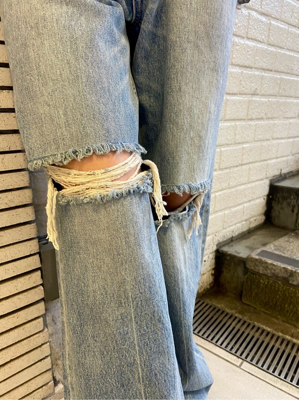 ブラック系のサンダル、ブラック系のTシャツ/カットソー、ブルー系のデニムパンツを着用したレディースの夏コーディネートの7枚目の写真