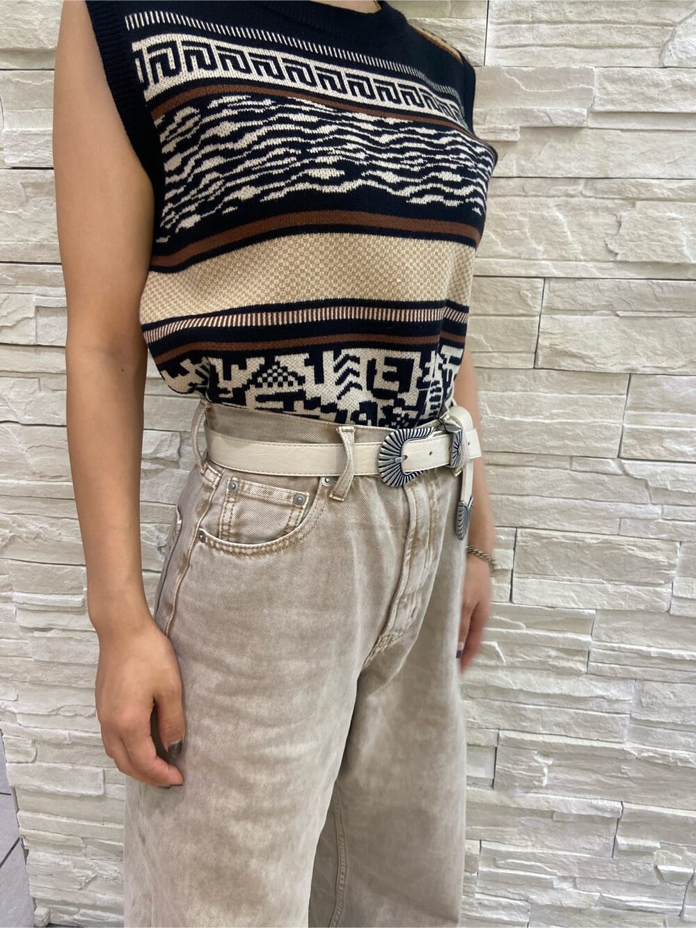 ブラック系のサンダル、ブラック系のタンクトップ、ベージュ系のデニムパンツを着用したレディースの夏コーディネートの5枚目の写真