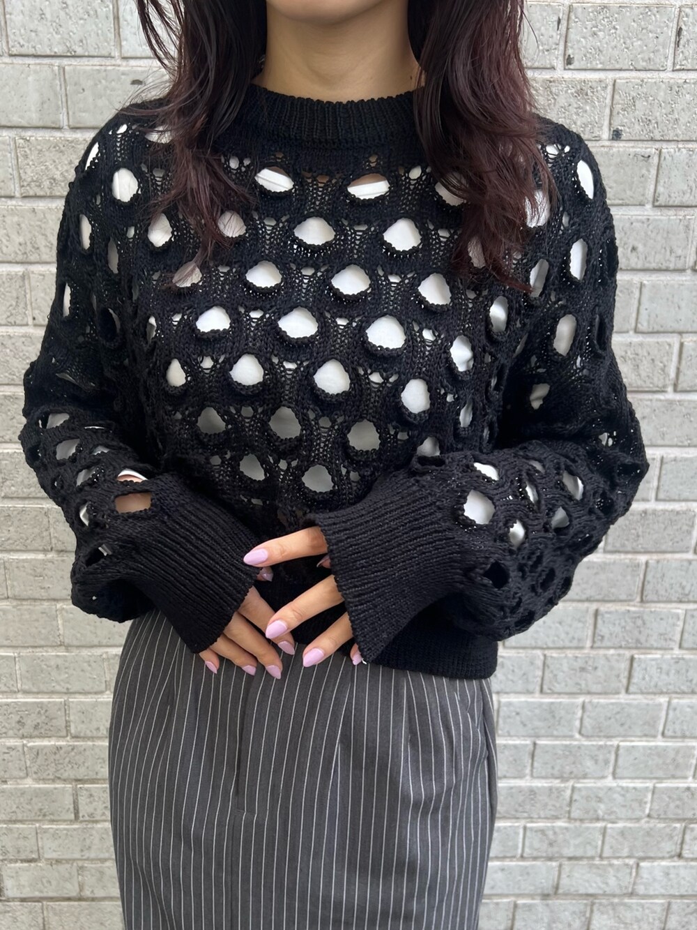 グレー系のスカート、ブラック系のニット/セーター、ブルー系のショルダーバッグを着用したレディースの冬コーディネートの5枚目の写真