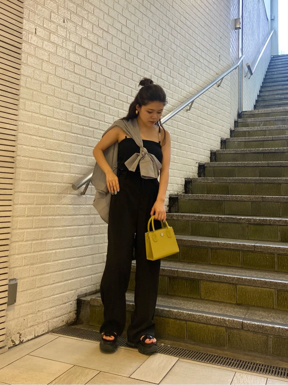 ブラック系のスラックス、ブラック系のサンダル、ブラック系のワンピースを着用したレディースの春コーディネートの6枚目の写真