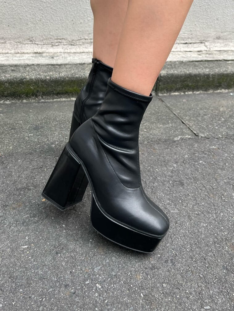 ブラック系のブーツ、ブラック系のワンピース、ホワイト系のスタジャンを着用したレディースの秋コーディネートの10枚目の写真