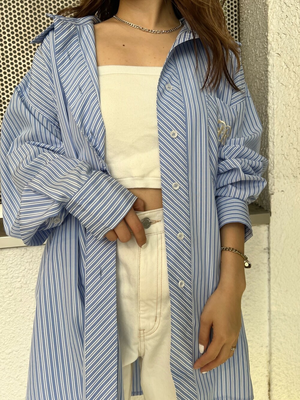 ホワイト系のデニムパンツ、ホワイト系のニット/セーター、ブルー系のシャツ/ブラウスを着用したレディースの春コーディネートの6枚目の写真