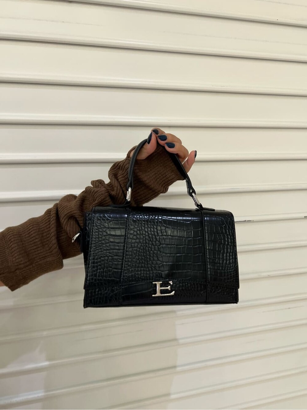 ブラウン系のワンピース、ブラック系のブーツ、ブラック系のショルダーバッグを着用したレディースの秋コーディネートの8枚目の写真