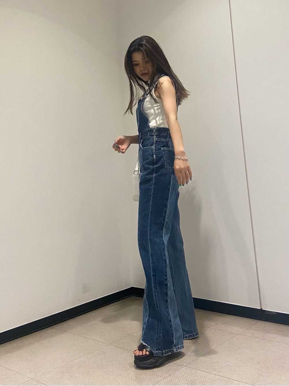 ホワイト系のタンクトップ、ブルー系のサロペット/オーバーオール、ブラック系のサンダルを着用したレディースの夏コーディネートの4枚目の写真