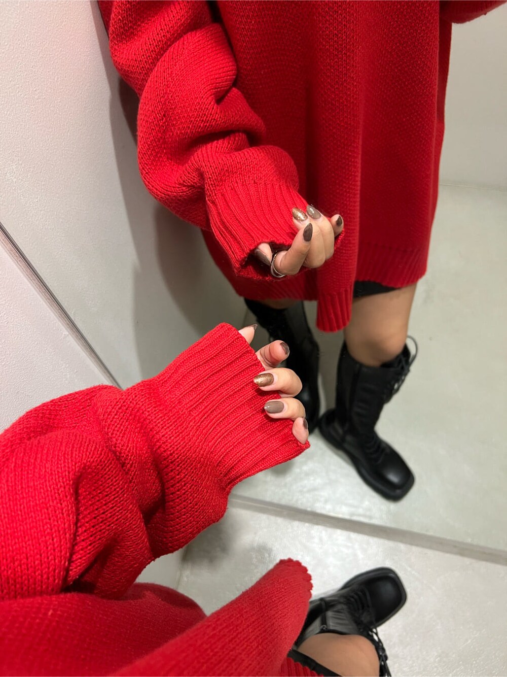 ブラック系のブーツ、レッド系のニット/セーター、ブラック系のスカートを着用したレディースの秋コーディネートの6枚目の写真