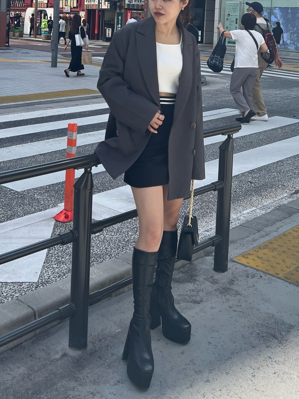 ブラック系のブーツ、ブラック系のショルダーバッグ、ブラック系のスカートを着用したレディースの秋コーディネートの6枚目の写真