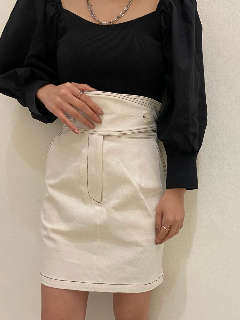 ホワイト系のスカート、ブラック系のサンダル、ブラック系のシャツ/ブラウスを着用したレディースの春コーディネートの2枚目の写真