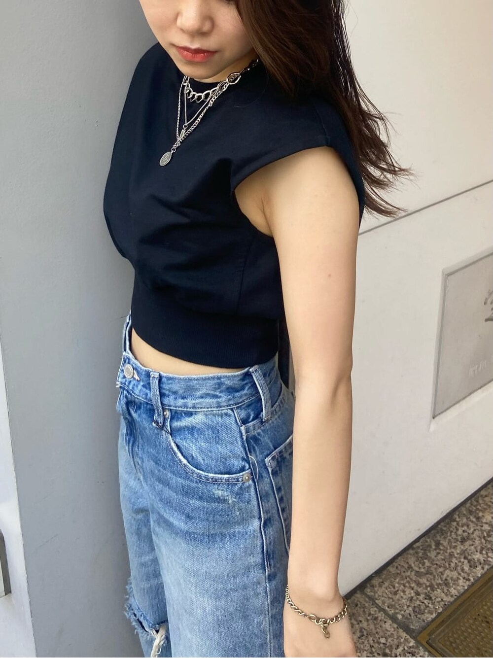 ブラック系のサンダル、ブラック系のTシャツ/カットソー、ブルー系のデニムパンツを着用したレディースの夏コーディネートの4枚目の写真