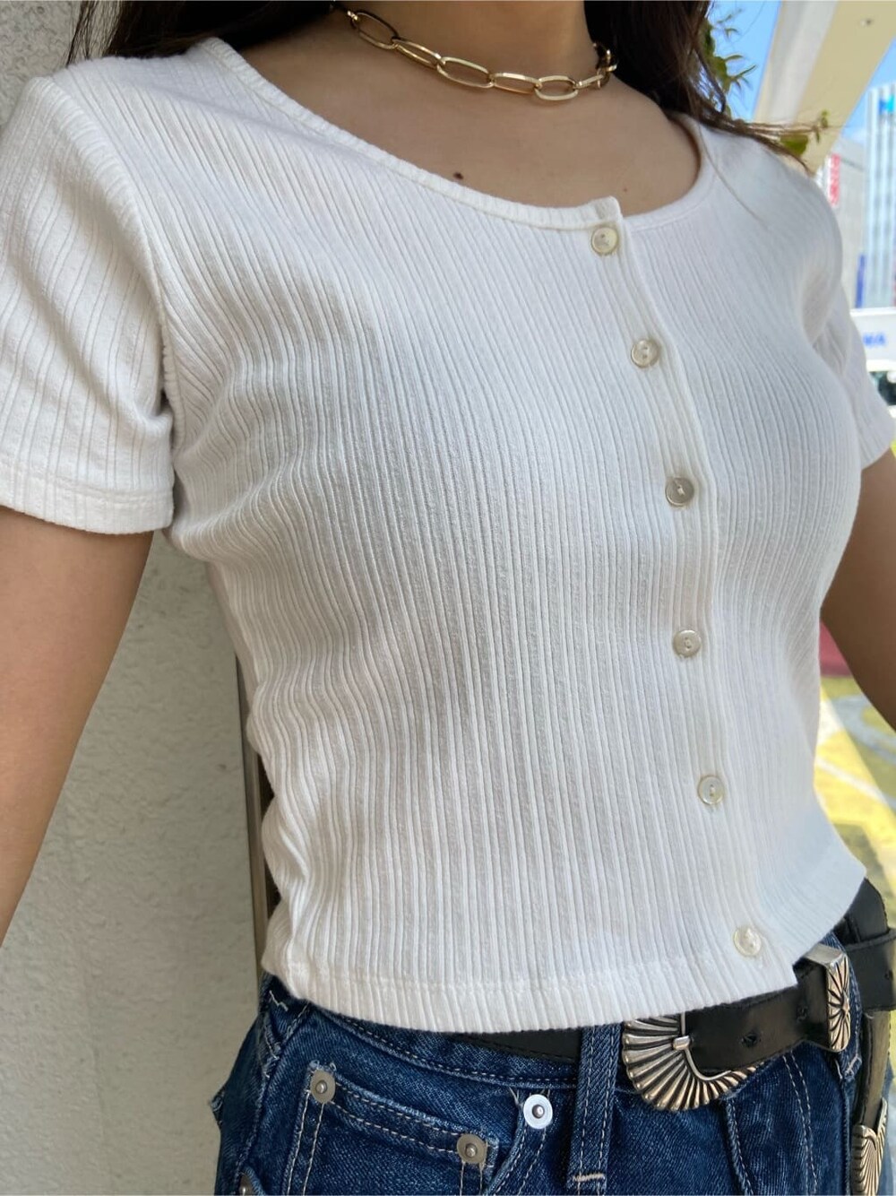 ブラック系のショルダーバッグ、ホワイト系のTシャツ/カットソー、ブルー系のデニムパンツを着用したレディースの春コーディネートの5枚目の写真