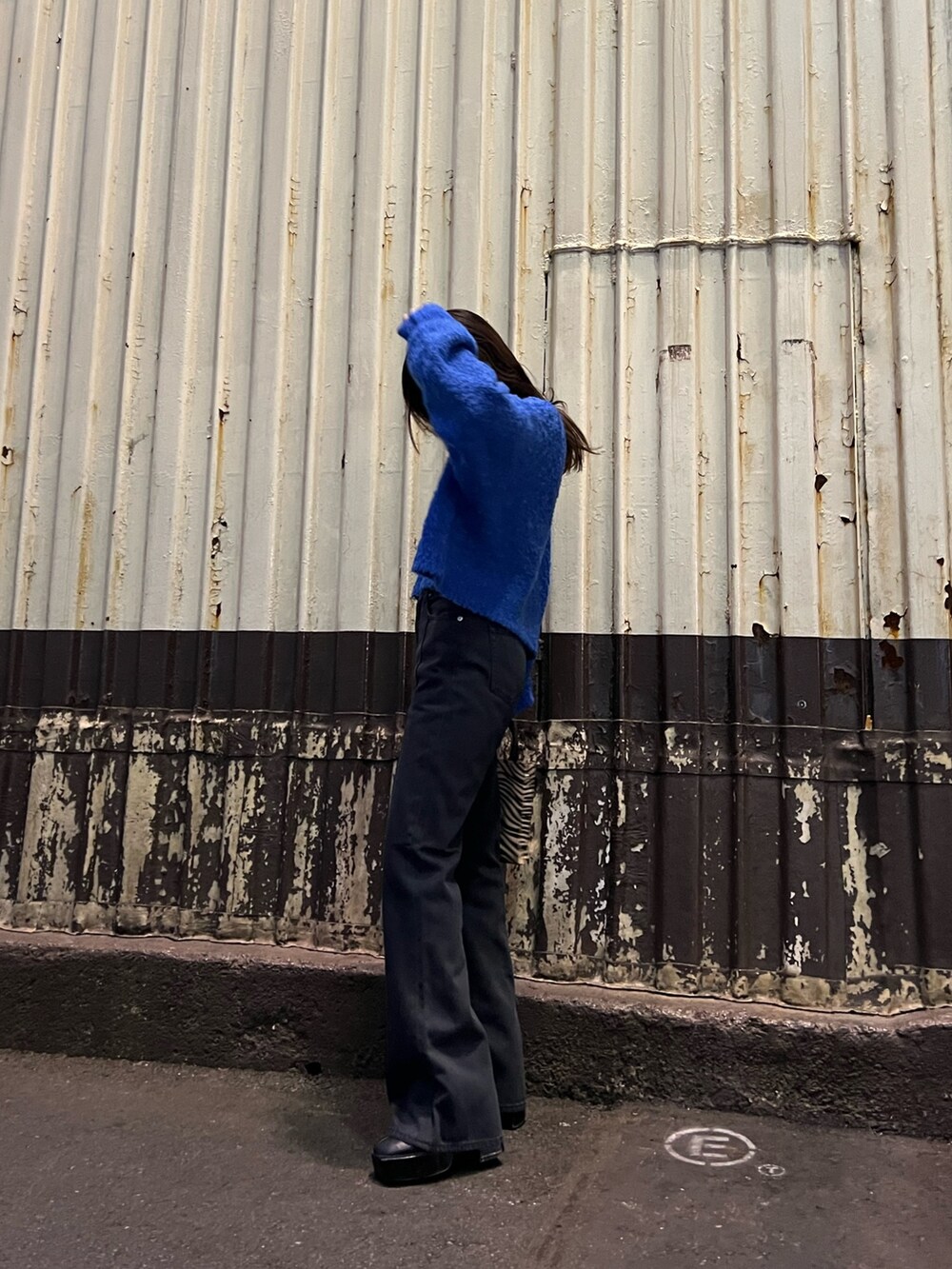 ブルー系のニット/セーター、その他のショルダーバッグ、ブラック系のデニムパンツを着用したレディースの冬コーディネートの5枚目の写真