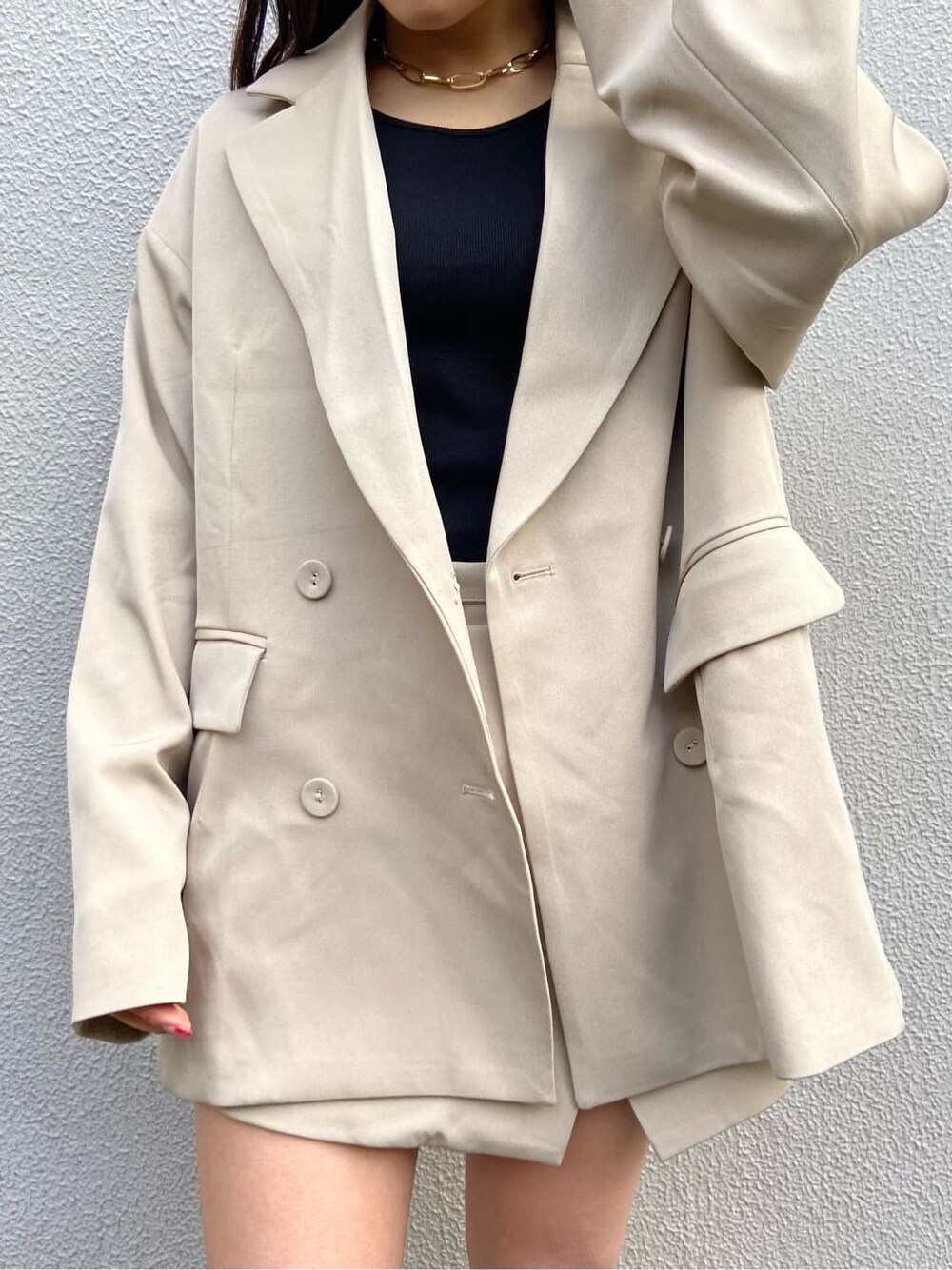 ブラック系のショルダーバッグ、ブラック系のTシャツ/カットソー、ベージュ系のスカートを着用したレディースの春コーディネートの3枚目の写真