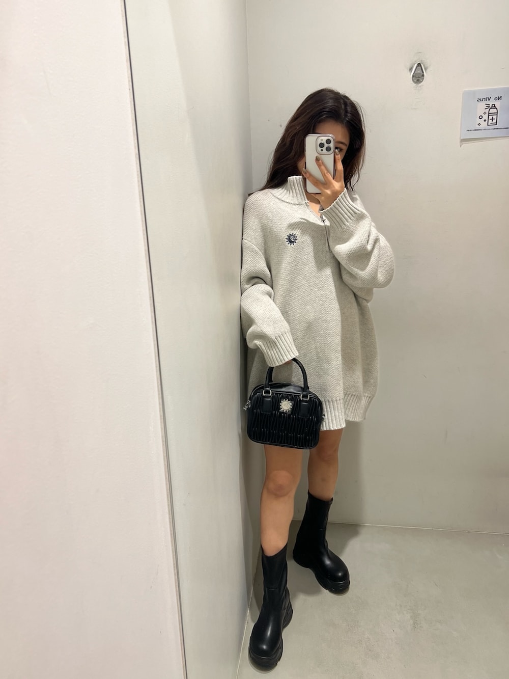 グレー系のニット/セーター、ブラック系のショルダーバッグ、ブラック系のブーツを着用したレディースの冬コーディネートの2枚目の写真