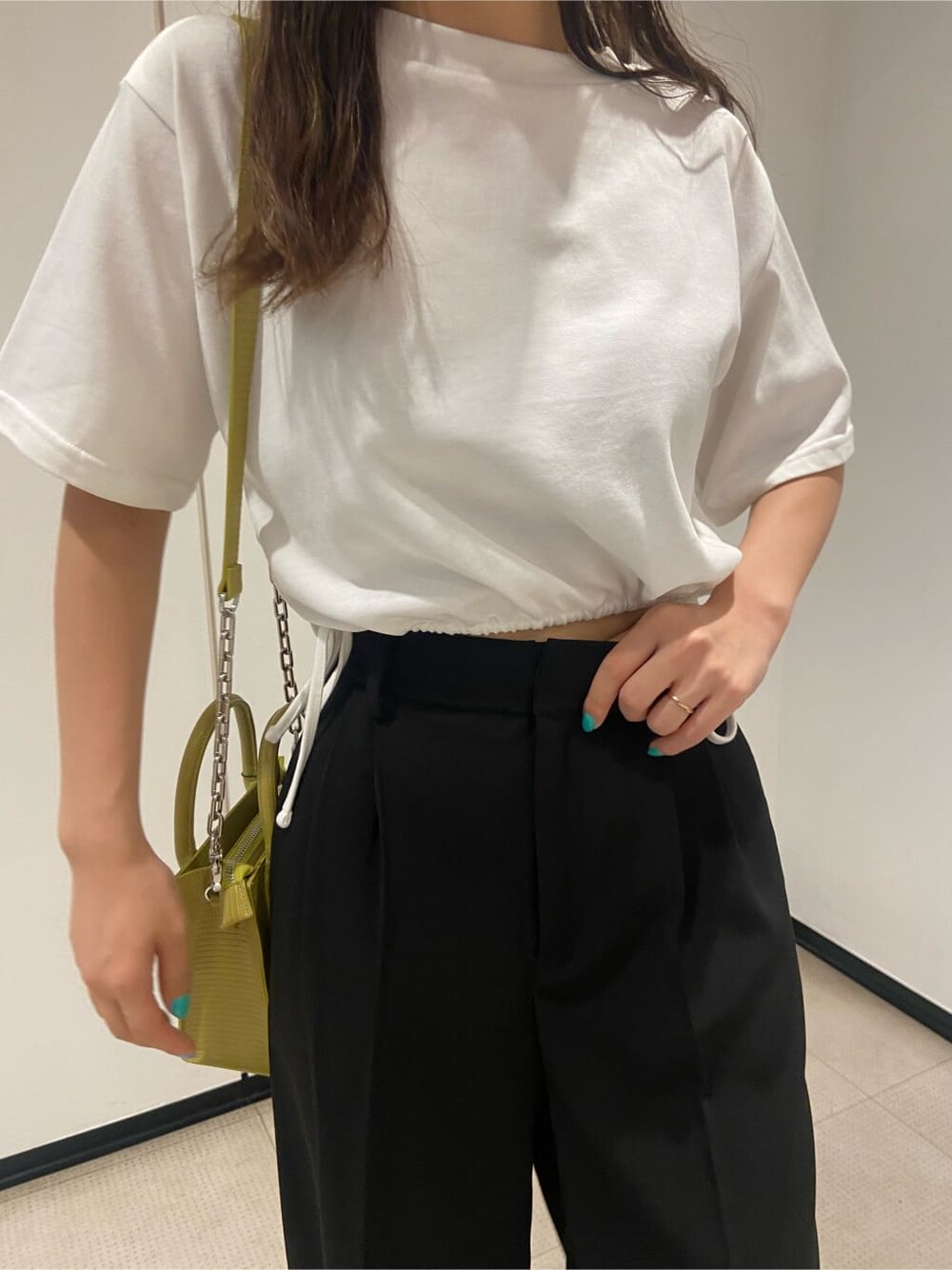 ブラック系のスラックス、ホワイト系のTシャツ/カットソー、イエロー系のショルダーバッグを着用したレディースの春コーディネートの8枚目の写真