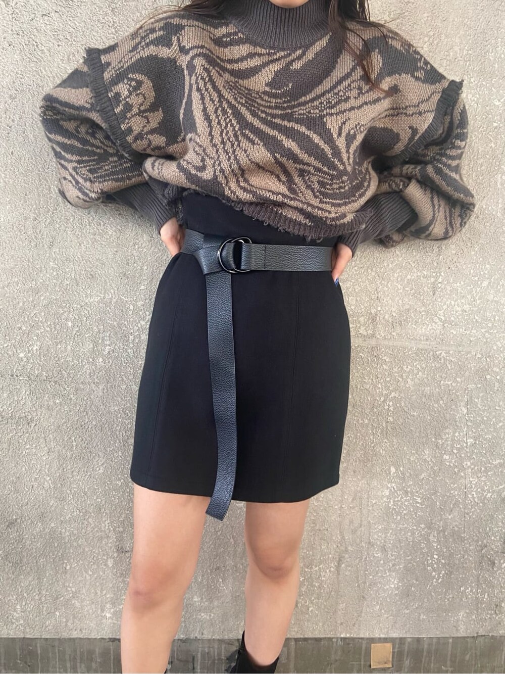 ブラック系のスカート、ブラック系のハンドバッグ、その他のニット/セーターを着用したレディースの秋コーディネートの3枚目の写真