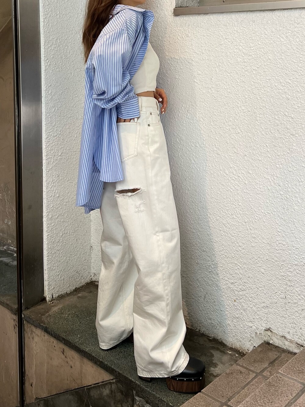 ホワイト系のデニムパンツ、ホワイト系のニット/セーター、ブルー系のシャツ/ブラウスを着用したレディースの春コーディネートの5枚目の写真