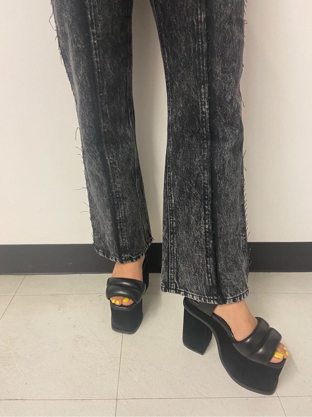 グリーン系のハンドバッグ、ブラック系のデニムパンツ、ホワイト系のニット/セーターを着用したレディースの夏コーディネートの5枚目の写真