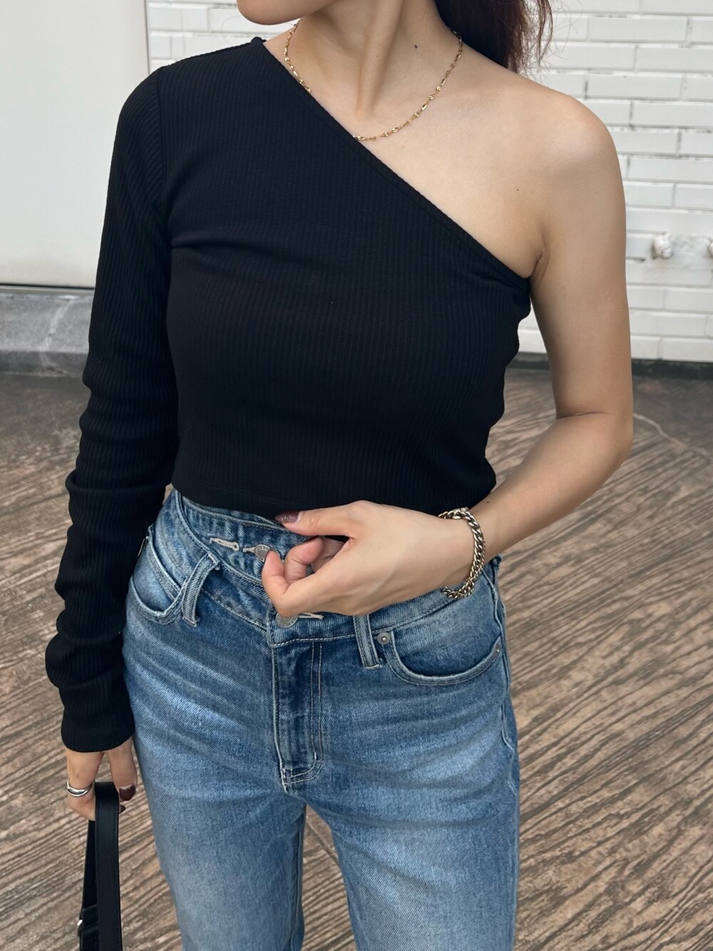 ブラック系のTシャツ/カットソー、ブラック系のサンダル、ブルー系のデニムパンツを着用したレディースの夏コーディネートの6枚目の写真