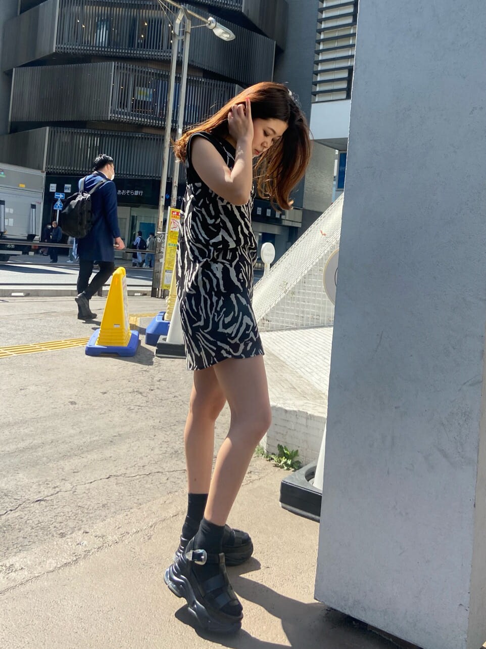 ベージュ系のテーラードジャケット、ブラック系のワンピース、ブラック系のサンダルを着用したレディースの春コーディネートの4枚目の写真